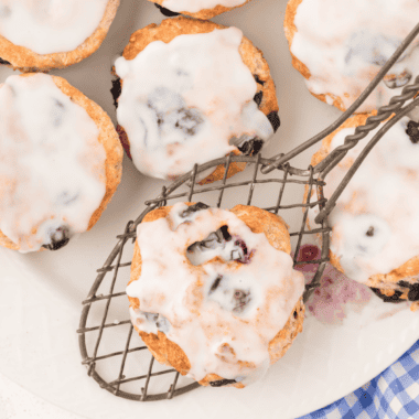 copycat panera blueberry scones with vanilla icing drizzle on cooling rack