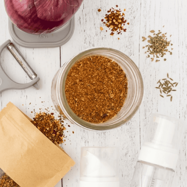 Spice mixture being whisked in a bowl or shaken in a sealed jar until evenly combined into a uniform rust colored seasoning blend.