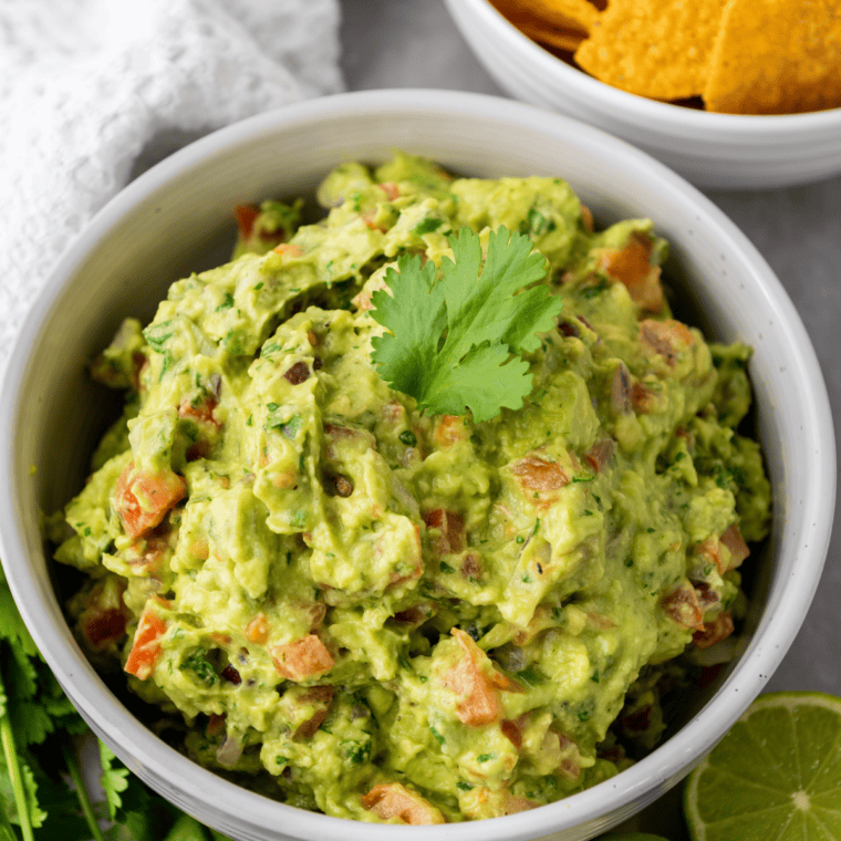 Finished vegan guacamole recipe served in a bowl with tortilla chips