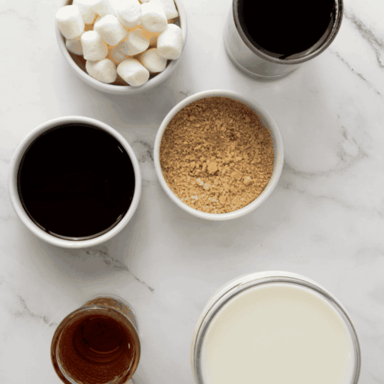 Ingredients for Jack Daniel's hot chocolate including dark chocolate, milk, heavy cream, cocoa powder, sugar, and a bottle of Tennessee whiskey