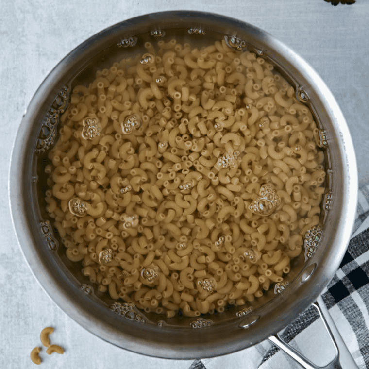 Elbow macaroni cooking in a pot of boiling salted water