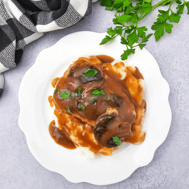 Copycat McCormick brown gravy over mashed potatoes and pork chops