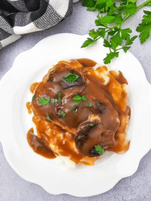 Copycat McCormick brown gravy poured over a bowl of creamy mashed potatoes