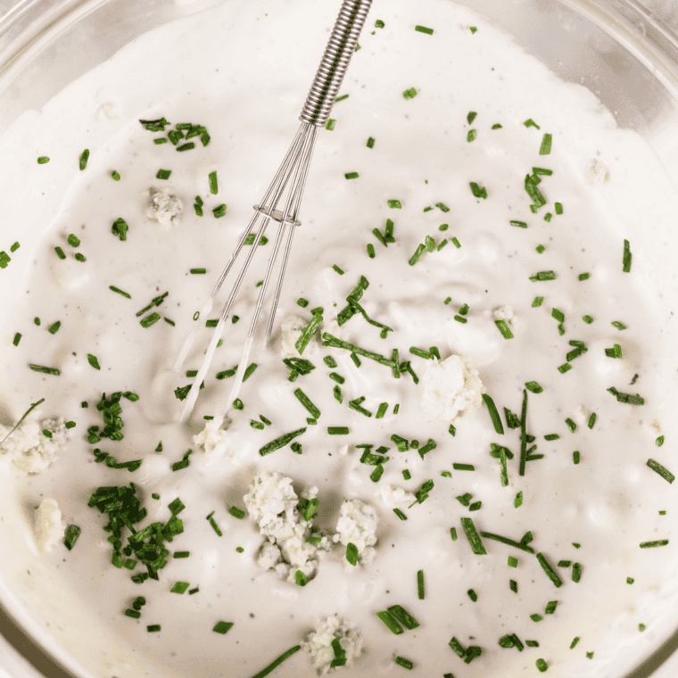 Whisking mayonnaise and lime juice together to make Mexican mayonesa.