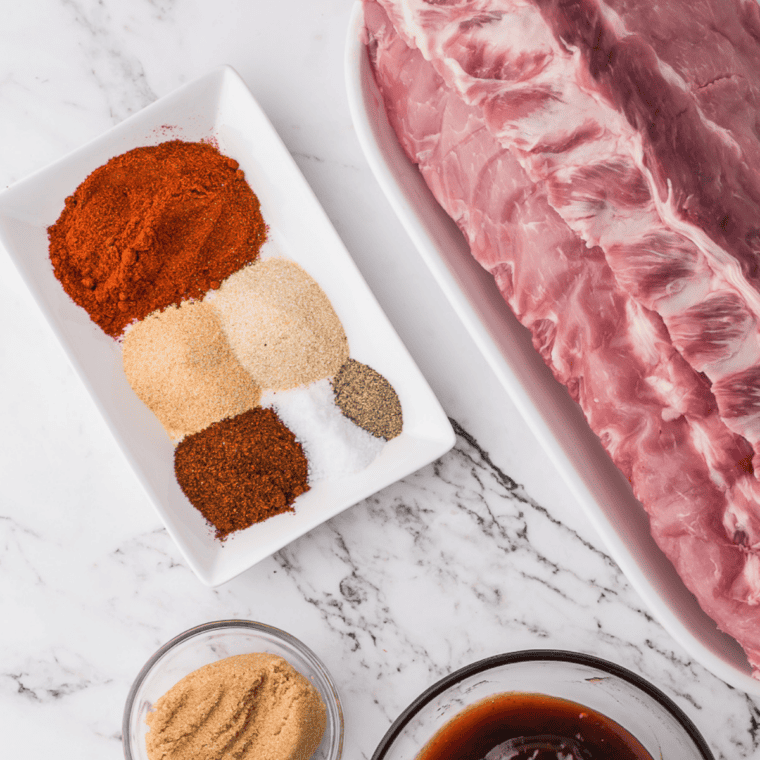 Ingredients for copycat Meat Church Honey Hog BBQ rub — sugar, brown sugar, honey powder, paprika, garlic powder, celery salt, and kosher salt in small bowls