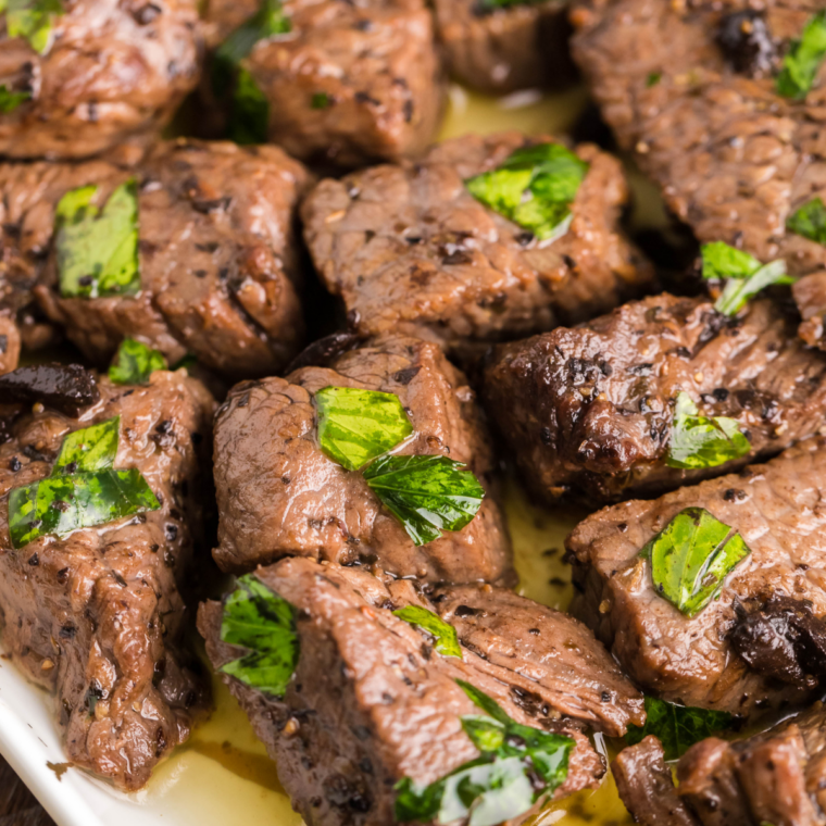 Ninja Crispi steak bites cooked until golden brown and served in a bowl with fresh herbs.