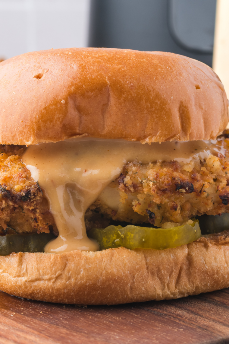 Two Chicken Big Mac copycat sandwiches on parchment with a side of fries and extra special sauce