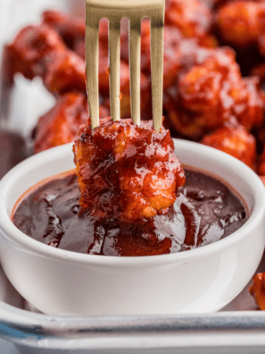Jack Daniel's sauce in a glass jar with a spoon drizzling the glaze