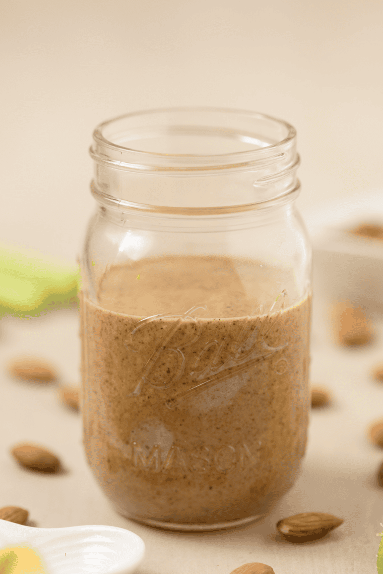 Smooth, glossy homemade almond butter in a glass jar