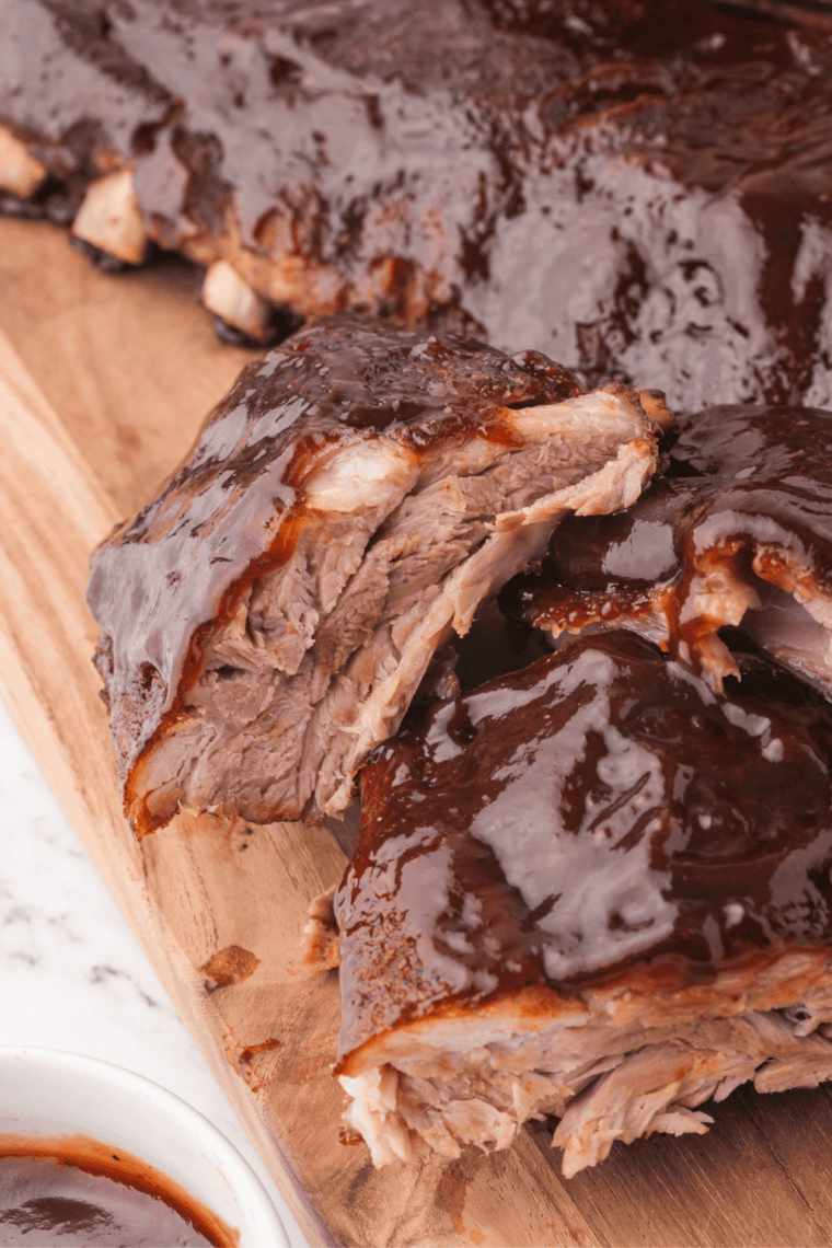 Oven baked baby back ribs with sticky barbecue sauce, sliced and served