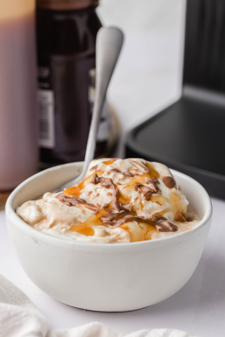 Close-up of dark chocolate fudge swirl and chocolate sundae sauce over the finished copycat ice cream.