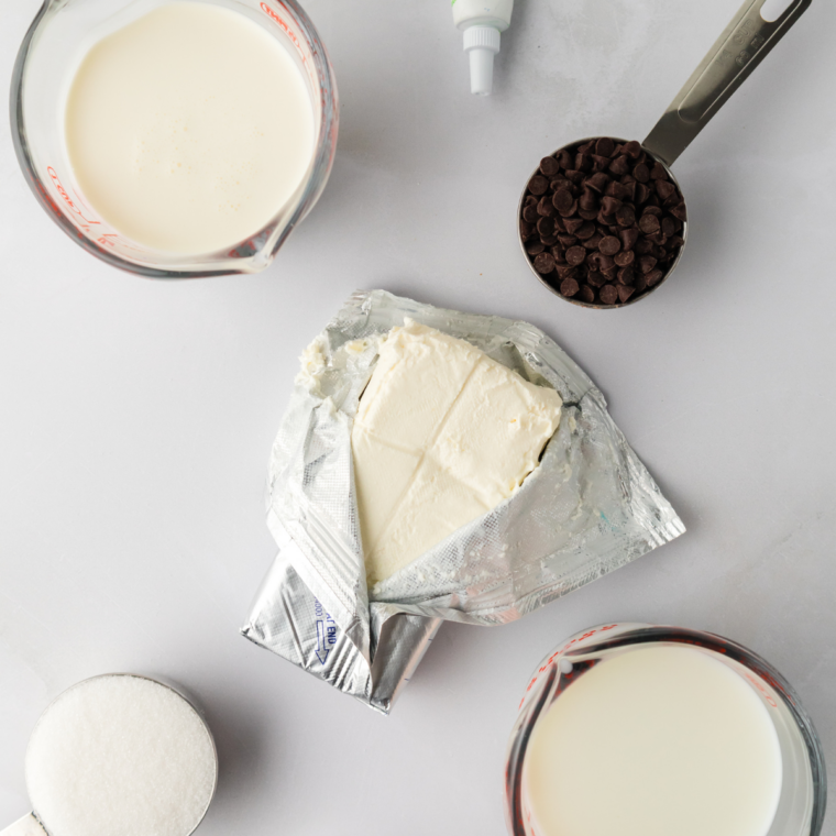 Ingredients for Ninja Creami mint chocolate chip ice cream: heavy cream, whole milk, sugar, cream cheese, peppermint extract, vanilla, green food coloring, and dark chocolate.