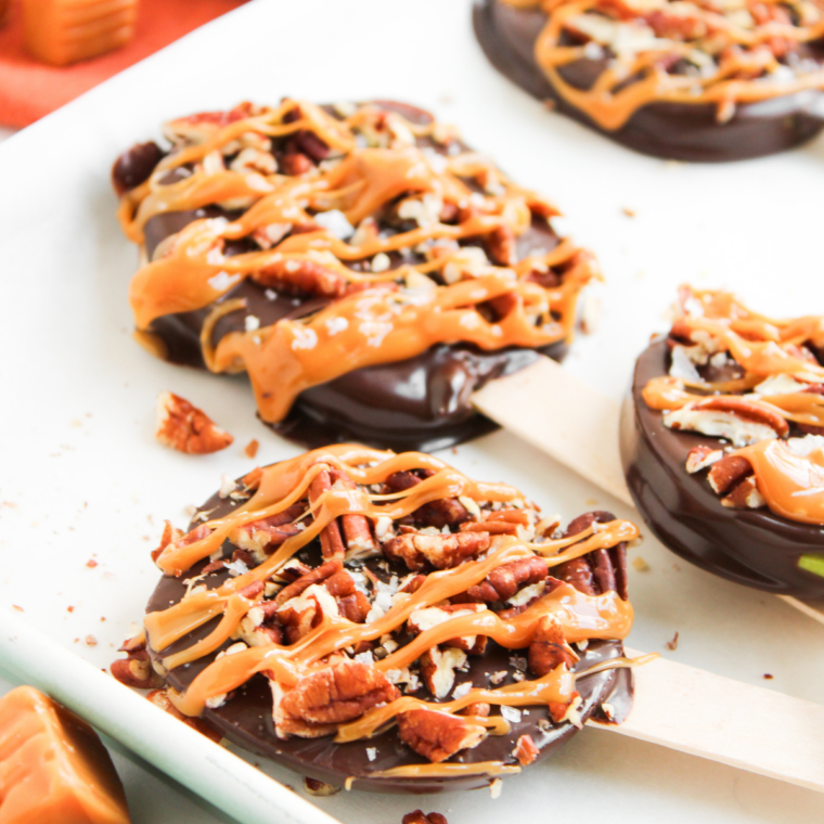 Melted caramel squares stirred smooth in a bowl for drizzling over apple pops