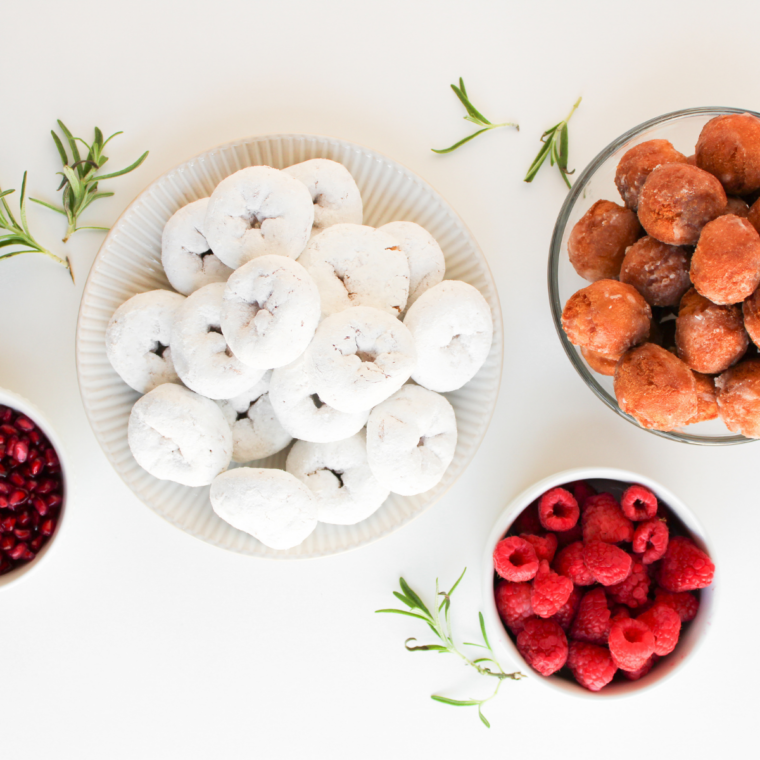 Ingredients for a Christmas donut wreath: mini powdered donuts, glazed donut holes, raspberries, pomegranate, rosemary