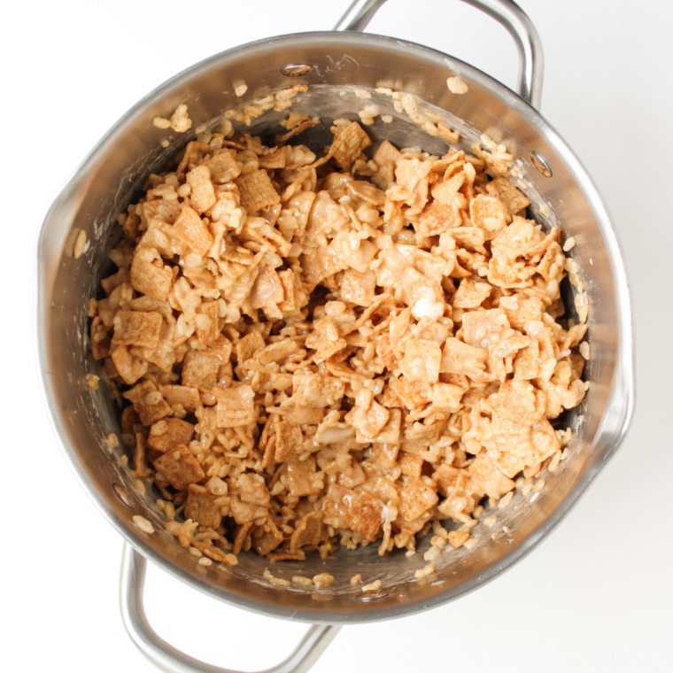 Cereal treat mixture pressed into an even layer in a foil-lined 9x13 baking dish
