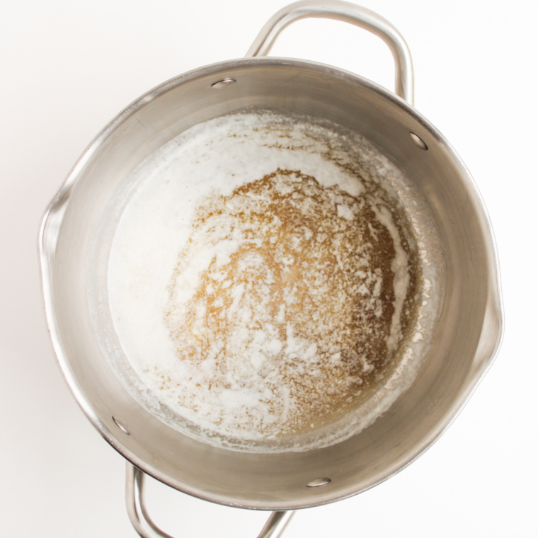 Unsalted butter melting in a large pot over medium-low heat