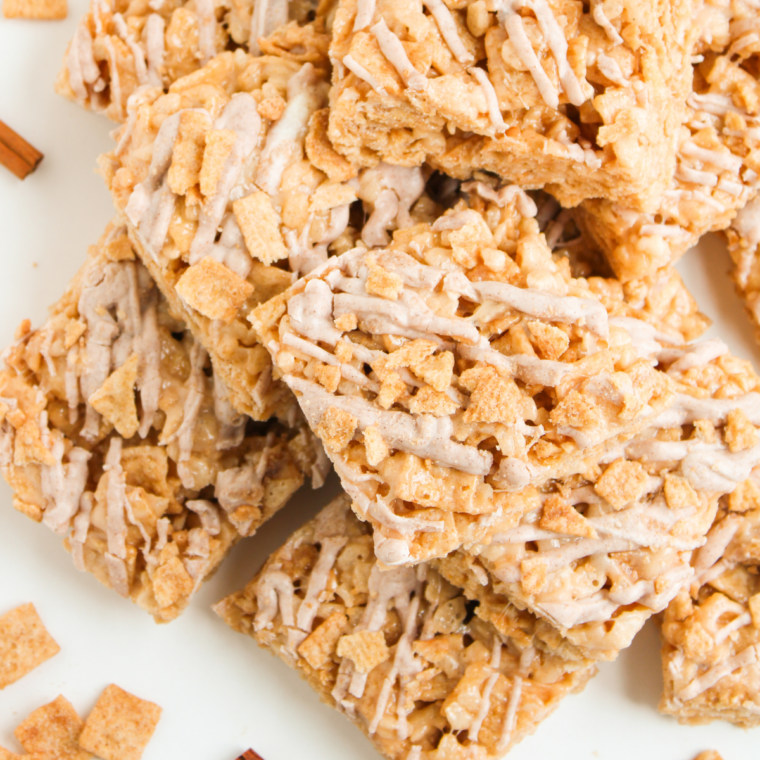 Cinnamon Toast Crunch Rice Krispie Treats sliced into bars with cinnamon white chocolate drizzle