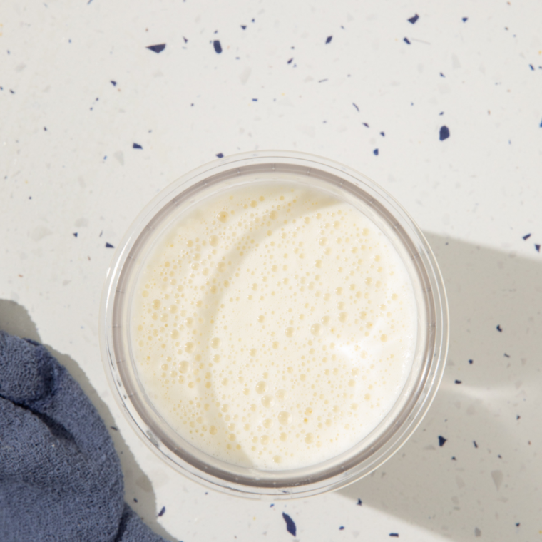 Cake batter ice cream base poured into a Ninja Creami pint, filled to the max line before freezing