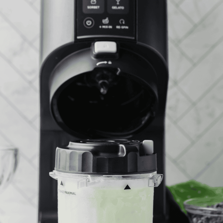 Mint ice cream base poured into a Ninja Creami pint container below the max fill line