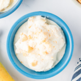 Two scoops of Ninja Creami Blue Bell banana pudding copycat ice cream in a white bowl with vanilla wafers