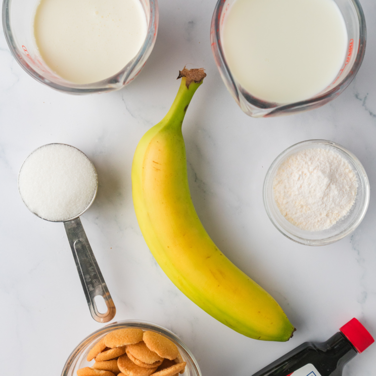 Ingredients for banana pudding ice cream: ripe banana, whole milk, heavy cream, condensed milk, pudding mix, and vanilla wafers