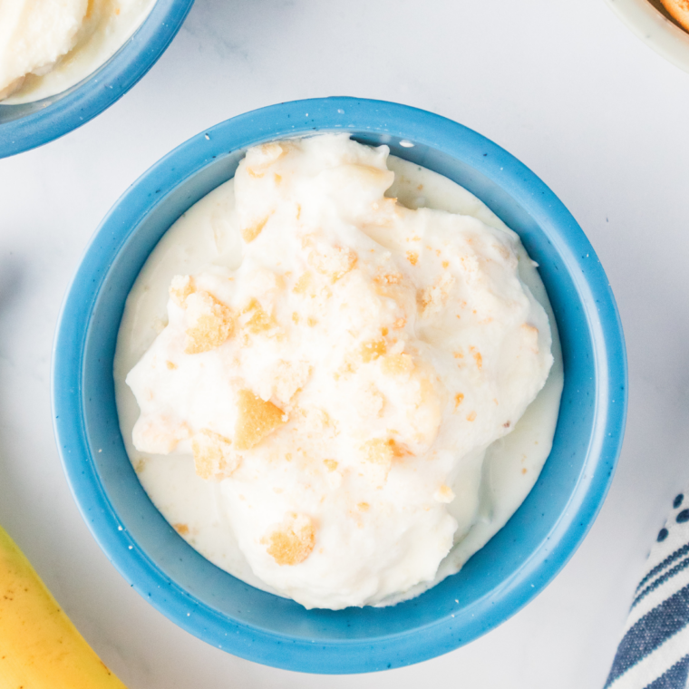 Two scoops of Ninja Creami Blue Bell banana pudding copycat ice cream in a white bowl with vanilla wafers