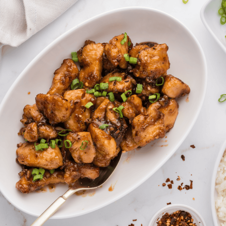 Caramelized chicken thighs glazed with sweet and smoky hickory brown sugar sauce on a dinner plate