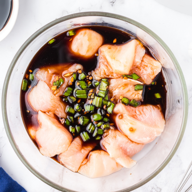 Raw chicken thighs marinating in copycat Lawry's teriyaki pineapple marinade in a glass dish