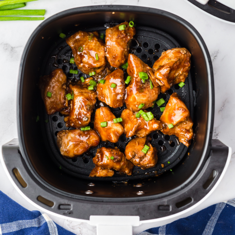 Golden teriyaki marinated chicken cooked in an air fryer basket with a glossy pineapple glaze
