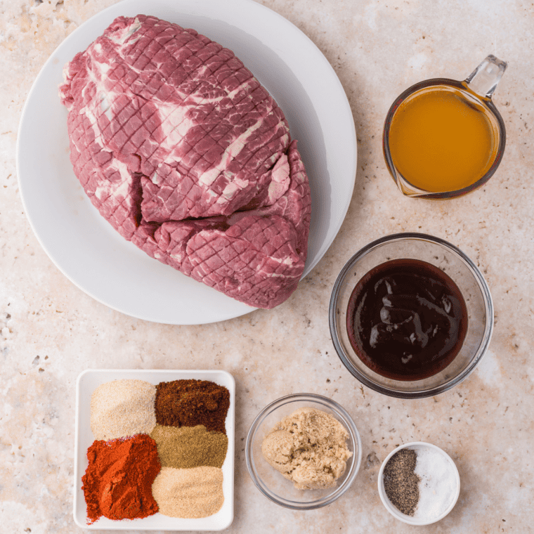 Ingredients for homemade al pastor seasoning mix on a table, including ancho chile powder, smoked paprika, annatto, cumin, and oregano
