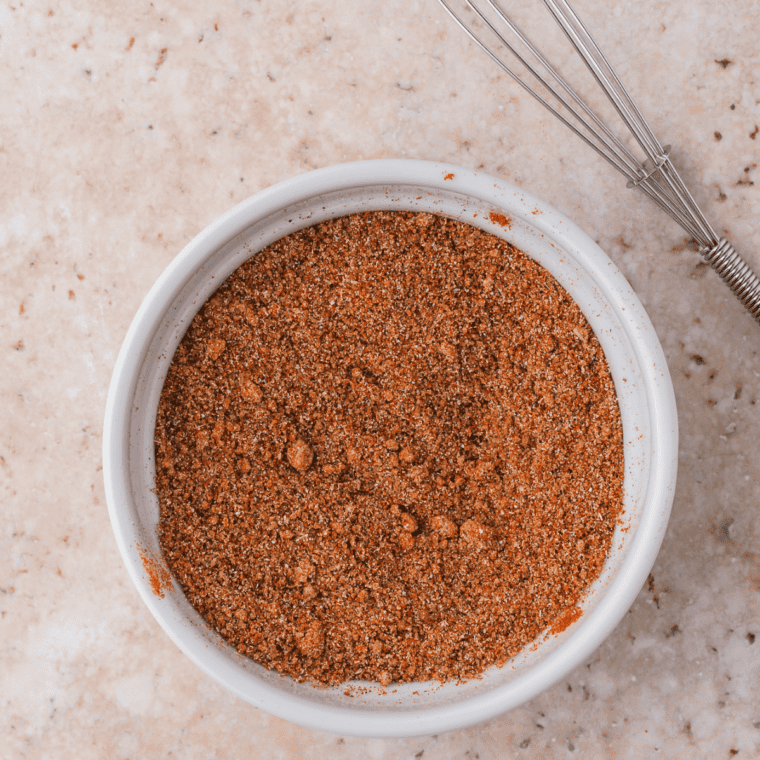Measuring spices into a small bowl to make homemade al pastor seasoning mix