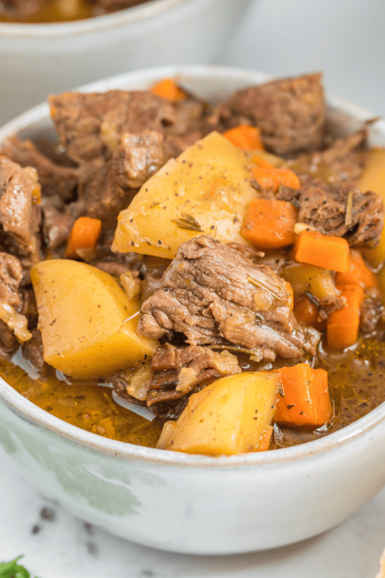 Close-up of thick beef stew gravy coating chunks of beef and carrots