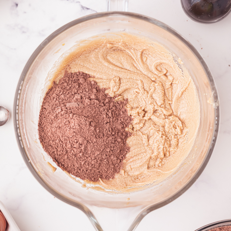 Thick chocolate cobbler batter spread evenly over melted butter in a slow cooker