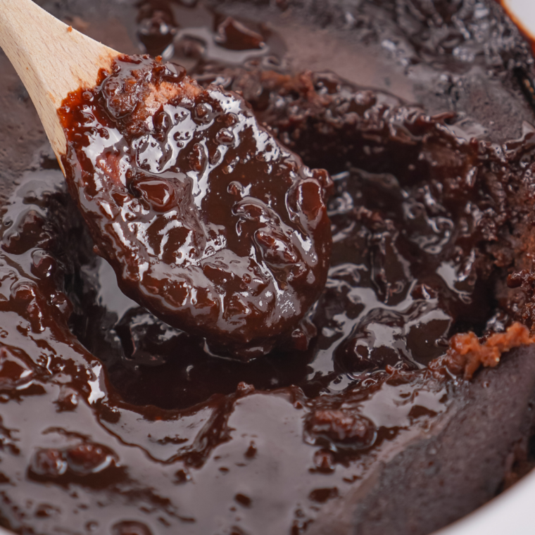 Finished chocolate cobbler resting in the crockpot with a set cake top over hot fudge sauce