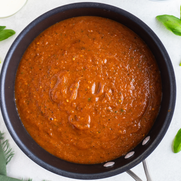 Condensed tomato soup being stirred and browned in butter in a saucepan before any liquid is added.