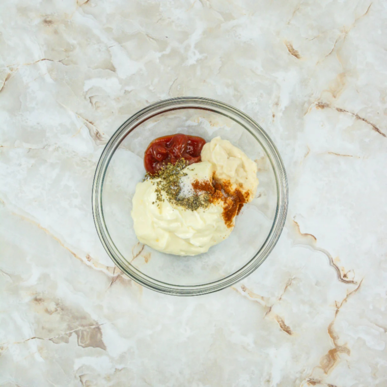 Whisking mayonnaise, hot sauce, Dijon, and rice vinegar into a smooth base