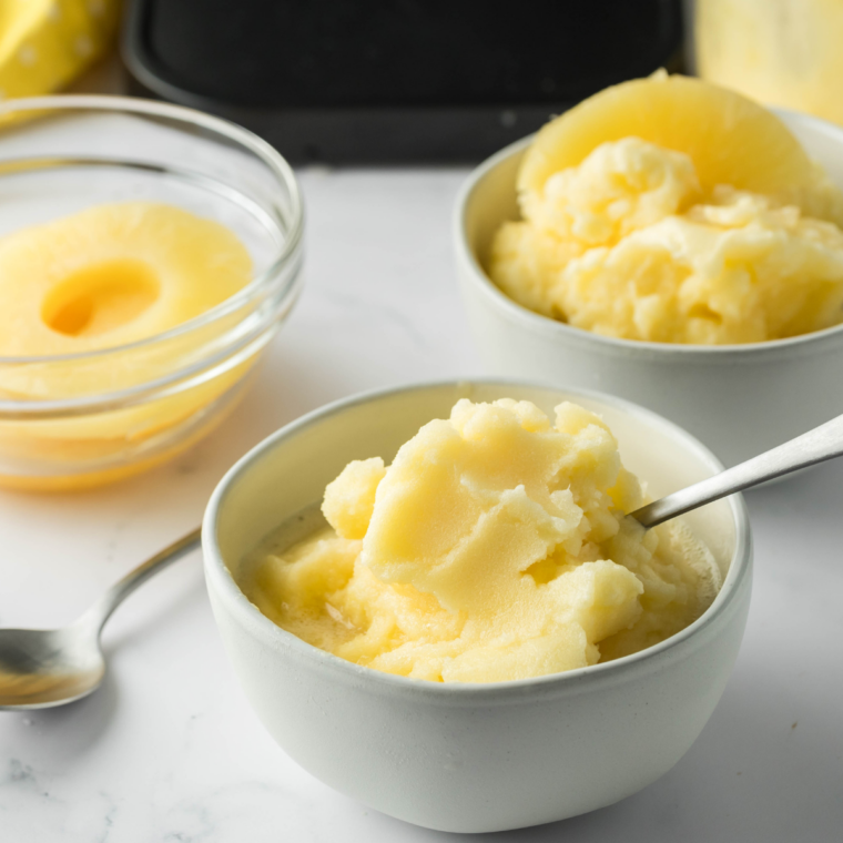 Two bowls of Ninja Creami Lemon Italian Ice served with lemon wheels for a refreshing summer dessert