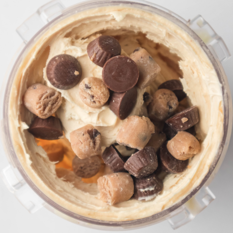 Adding chopped peanut butter cups and chocolate chips into the Ninja Creami mix-in hole