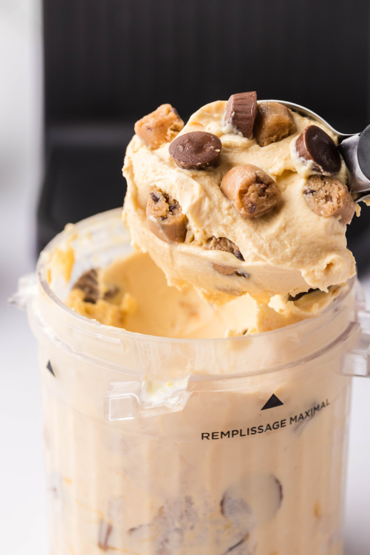Ice cream scoop lifting a spoonful of creamy Ninja Creami peanut butter ice cream from the pint.