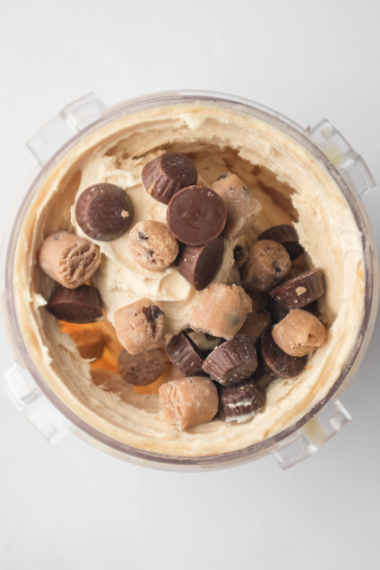 Ice cream scoop lifting a spoonful of creamy Ninja Creami peanut butter ice cream from the pint.
