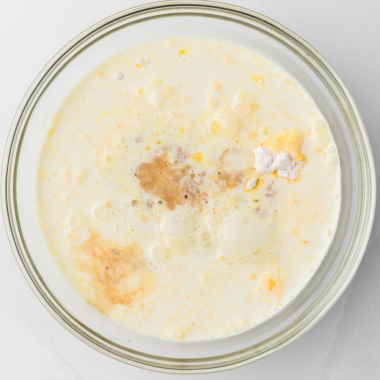 Granulated sugar spread in an even layer in a dry light-colored saucepan