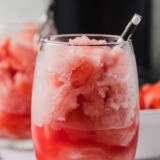 Scoop of Ninja Creami watermelon Italian ice in a chilled glass with a fresh watermelon wedge garnish