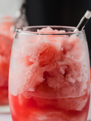 Scoop of Ninja Creami watermelon Italian ice in a chilled glass with a fresh watermelon wedge garnish