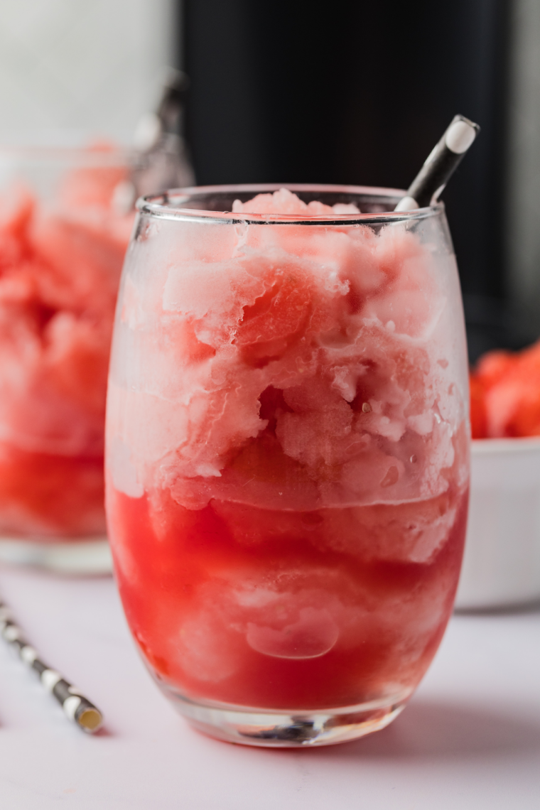 Bright pink watermelon Italian ice made in the Ninja Creami, topped with mint leaves