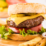 Two juicy cheeseburgers with melted American cheese on toasted buns, made with the Ninja Crispi burger recipe