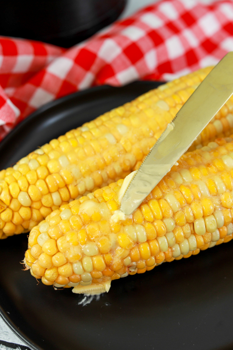 Buttered corn on the cob cooked in the Ninja Crispi, sprinkled with flaky salt and parsley