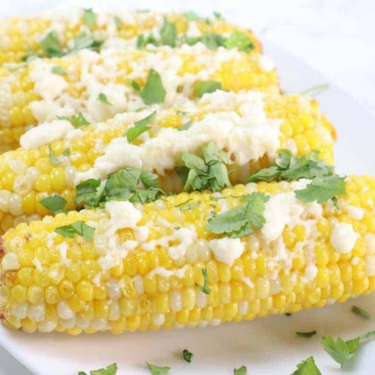 Street corn style Ninja Crispi corn with cotija cheese, chili powder, and lime wedges