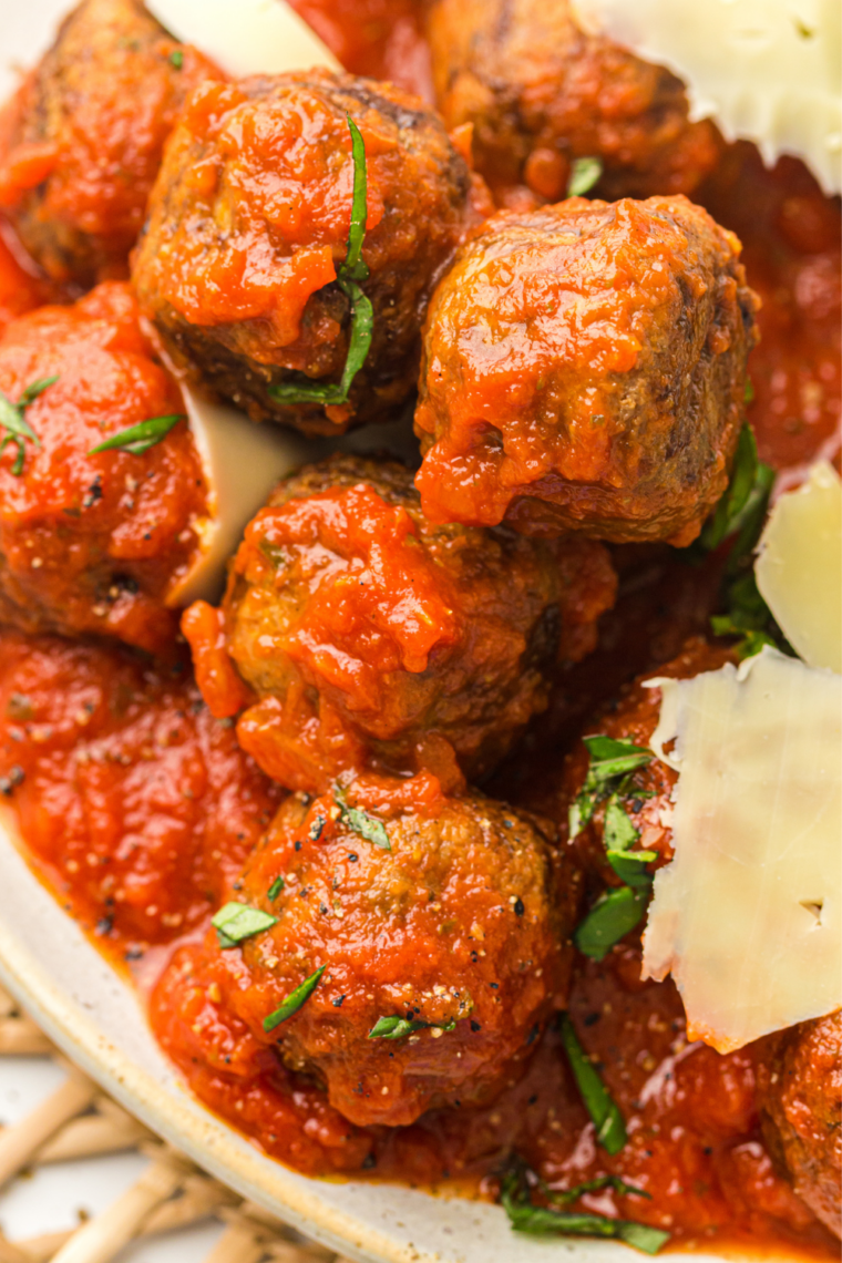 Ninja Crispi meatballs served over spaghetti with marinara sauce, fresh basil, and grated Parmesan