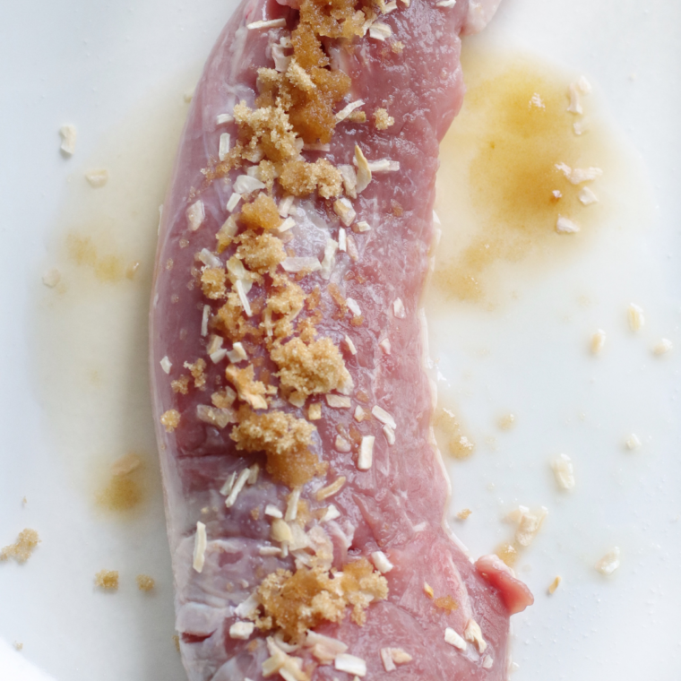 Rubbing smoked paprika and seasonings onto an oiled pork tenderloin for the Ninja Crispi