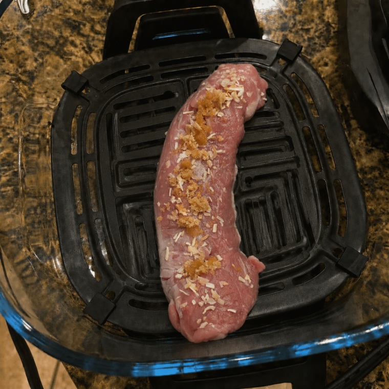 Pork tenderloin air frying on the crisper plate inside the Ninja Crispi with the PowerPod set to Air Fry
